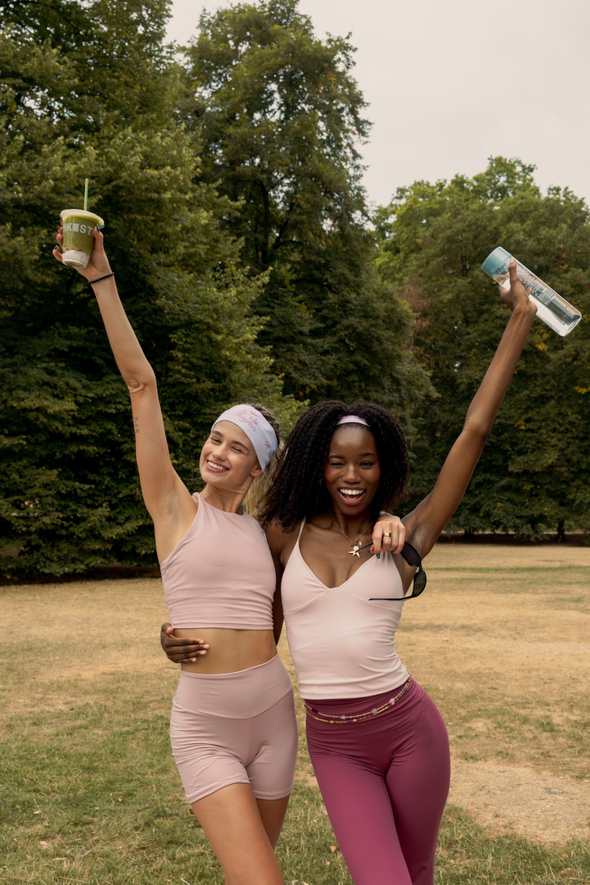 Two members cheering with their drinks after Pilates in Hyde Park